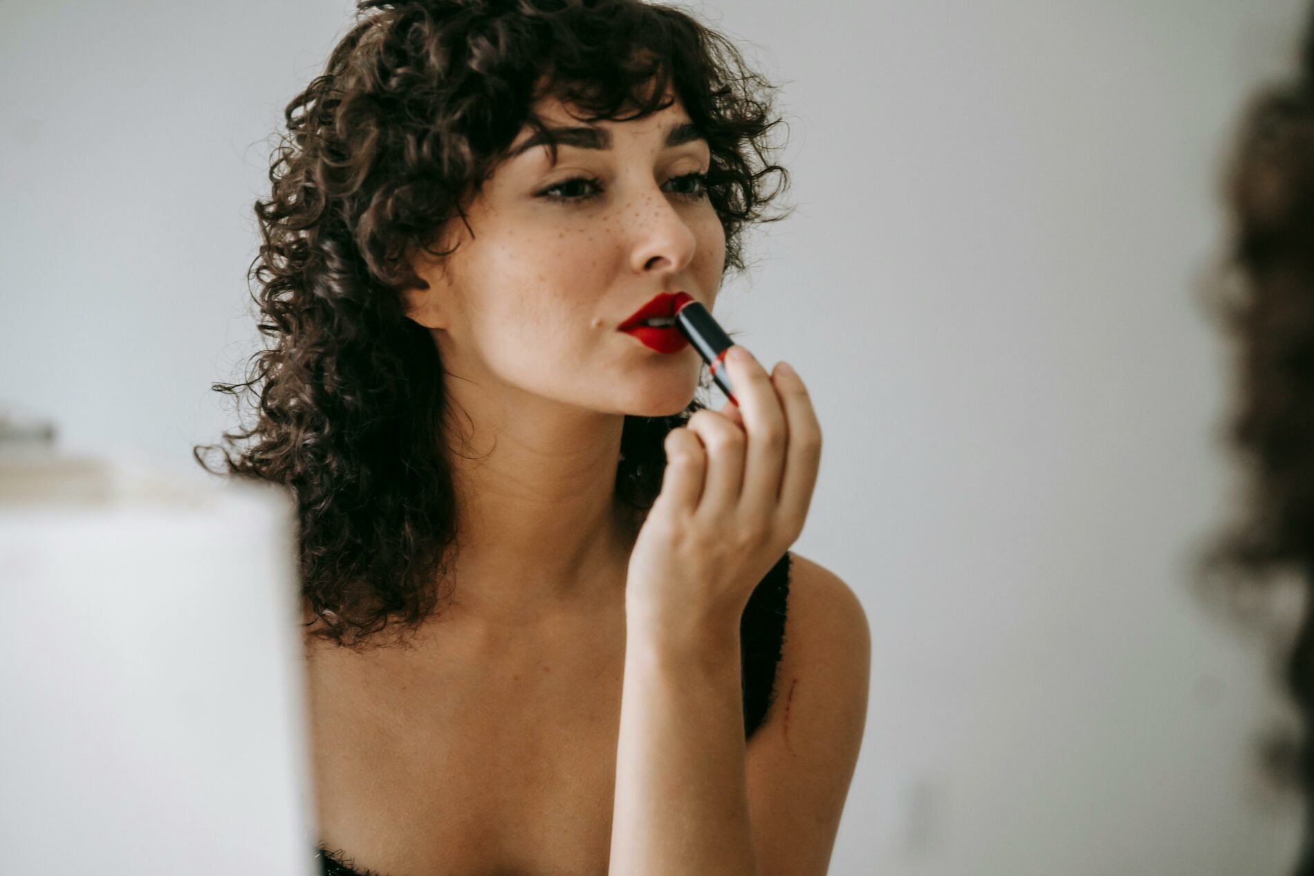 Femme qui réalise un maquillage léger pour un teint frais.