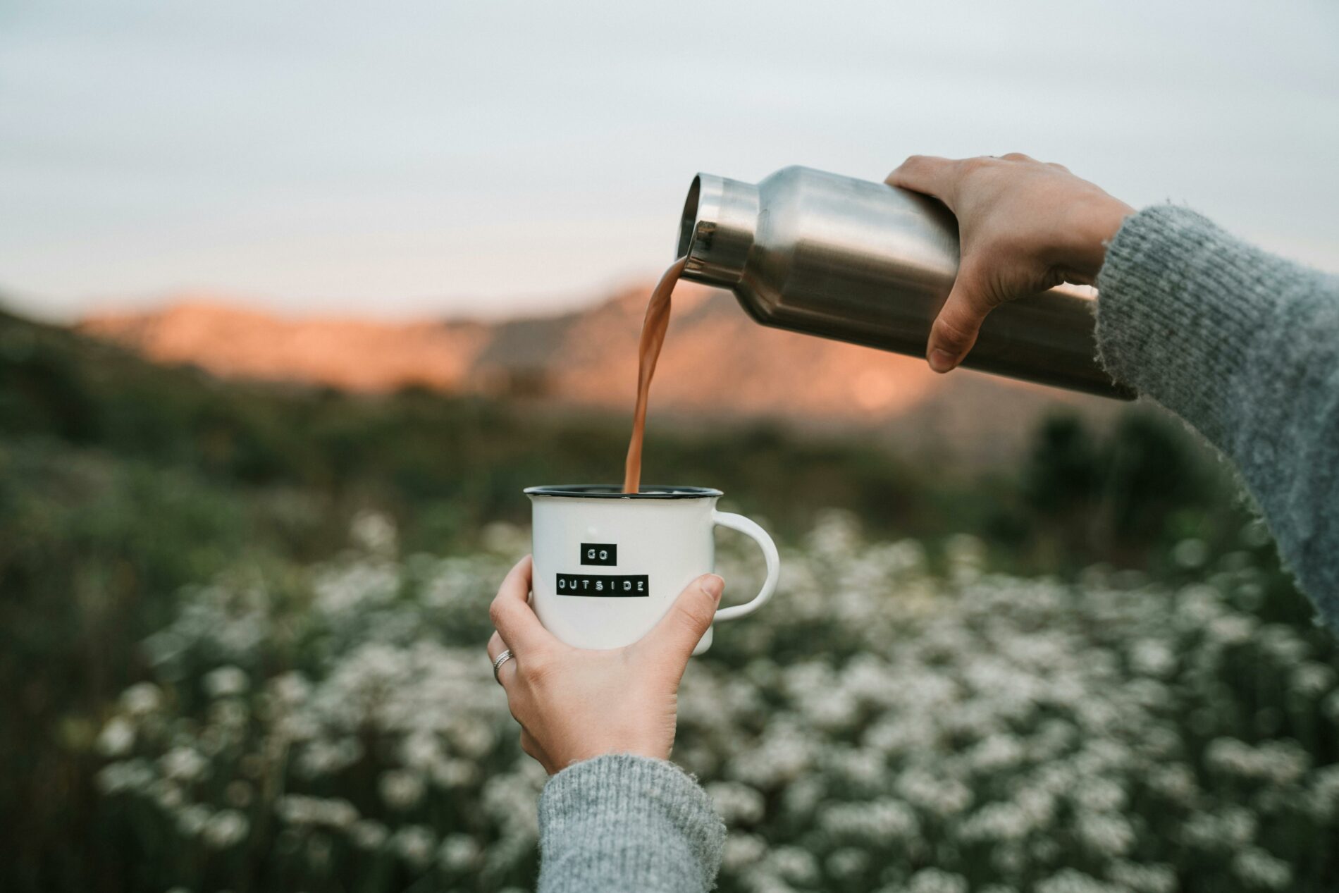 Café versé dans une tasse, en balade, lors d'une routine matinale énergisante en extérieur