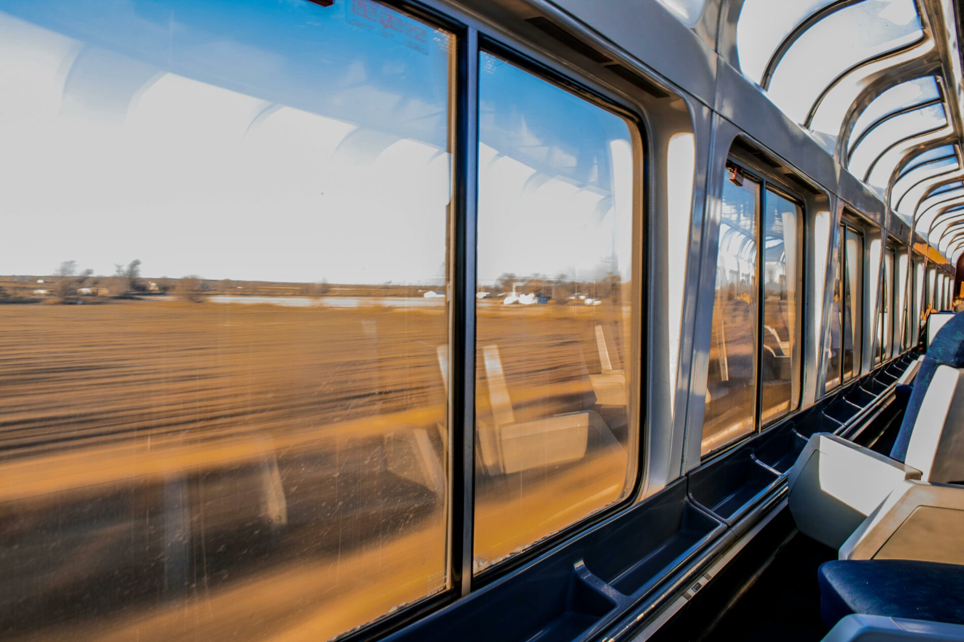 Fenêtre d'un train en route, pour des voyages écoresponsables et éthiques.